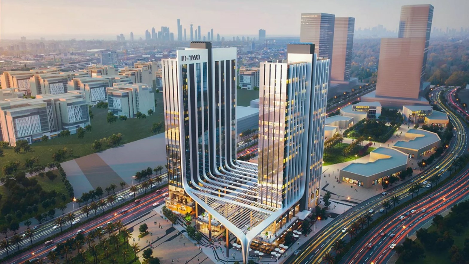 Vista aérea de un hotel futurista con una arquitectura innovadora, rodeado de áreas verdes y una ciudad moderna en el fondo. La iluminación y el diseño reflejan un enfoque vanguardista en la hospitalidad.