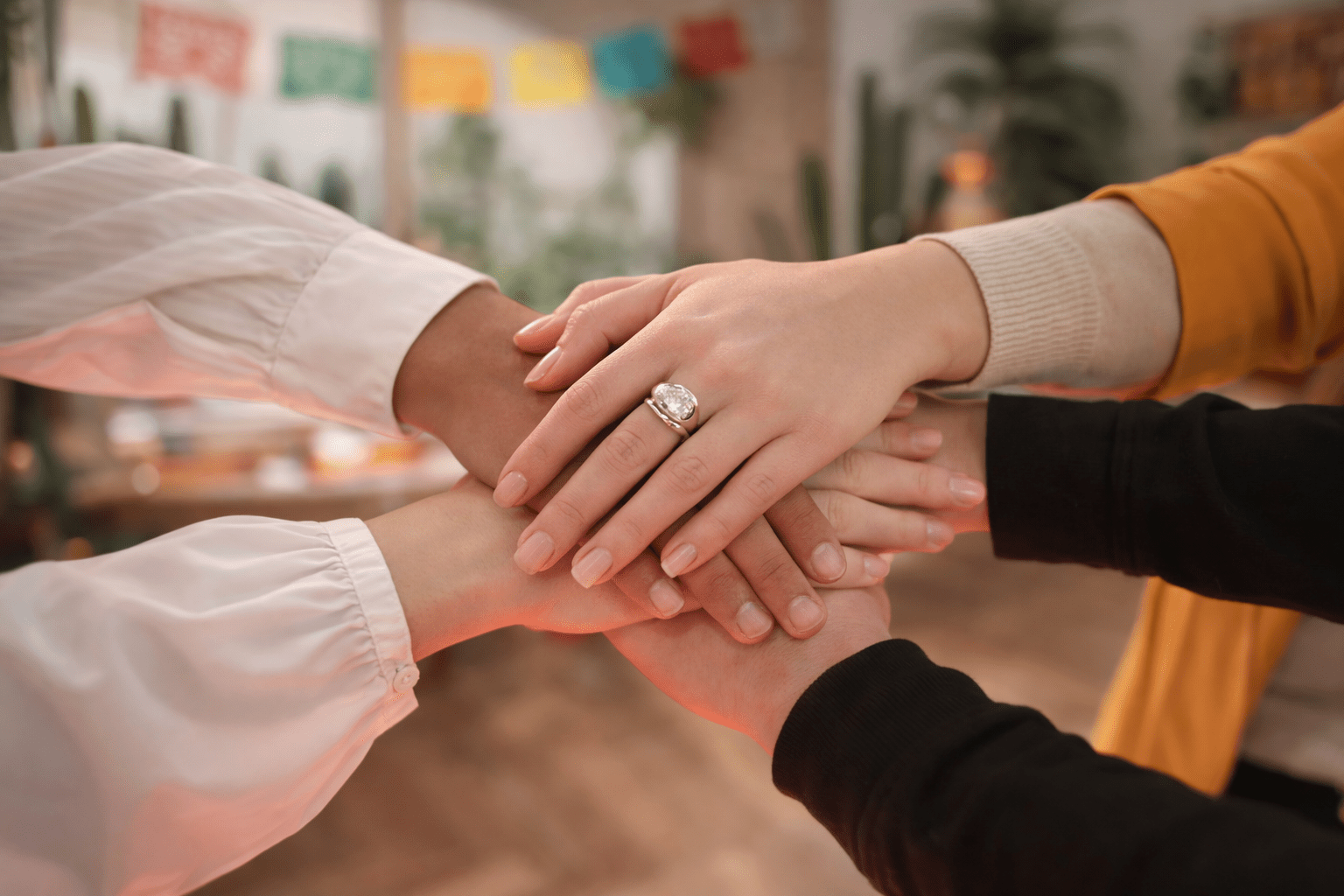 Manos de mujeres líderes latinoamericanas entrelazadas en gesto de unidad, representando sororidad, fuerza colaborativa y compromiso con el crecimiento de la industria MICE en México